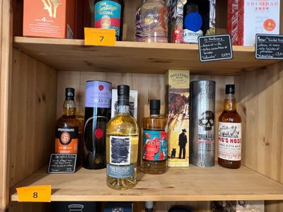 de nombreuses bouteilles d'alcool sur une étagère dans un magasin