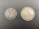 two silver coins, one of which has a bust and one of which is a bust