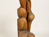 wooden sculpture of a woman and two children sitting on top of a rock