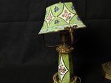 a green lamp with a green shade sitting on top of a table