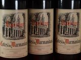 three bottles of red wine are lined up on a table