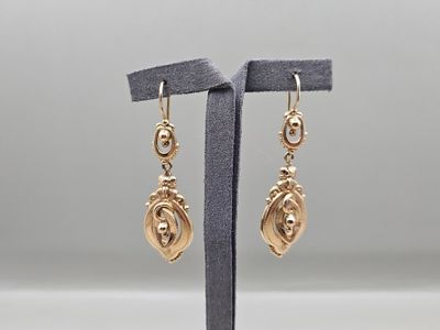 une paire de boucles d'oreilles plaquées or sur un présentoir