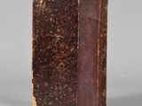 an old book sitting on top of a table next to a gray background