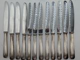 five knives and six knives on a white table