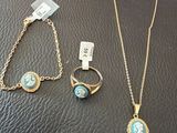 three pieces of jewelry are sitting on a black leather surface