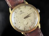 a close up of a wrist watch with a brown leather strap