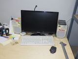 un bureau sur lequel se trouvent un ordinateur, un clavier, une souris et d'autres objets