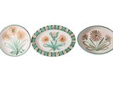 trois assiettes ornées de fleurs peintes sur fond blanc