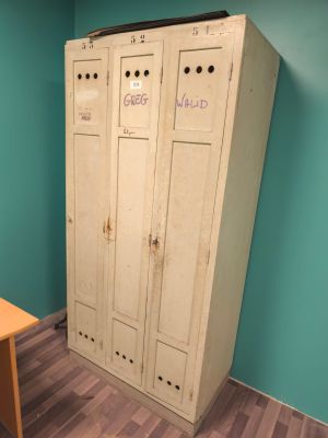 a large white locker in the corner of a room next to a table