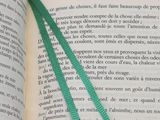 a book with a green bookmark on top of an open book