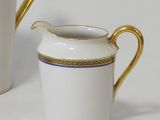a white and gold pitcher and a white and gold pitcher