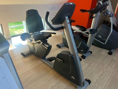 a row of stationary exercise bikes in a gym
