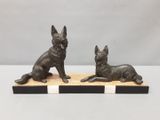 une paire de figurines de chiens en bronze posées sur un socle en bois