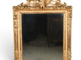 une image représentant un miroir à cadre doré posé sur un sol blanc