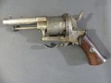 a gun that is sitting on a table with a wooden handle