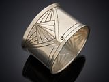 gros plan d'une bague en argent sur une surface noire