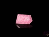 un quartz rose posé sur une surface noire