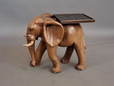 un petit éléphant en bois avec un plateau sur le dos