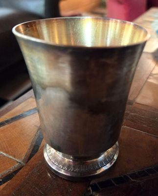 une coupe en argent posée sur une table en bois