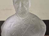 a glass bust of a man with a cross on it