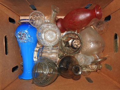 une boîte en carton remplie de bouteilles en verre et d'un vase bleu