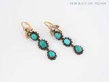 a pair of earrings with turquoise stones and diamonds
