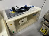 a microwave with a cord on top of it in a room