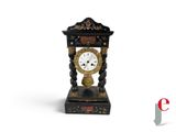 a black and gold clock sitting on a white surface
