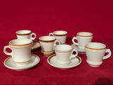 plusieurs tasses et soucoupes posées sur une nappe rouge
