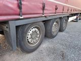 a red semi truck with a flat tire parked on the side of the road