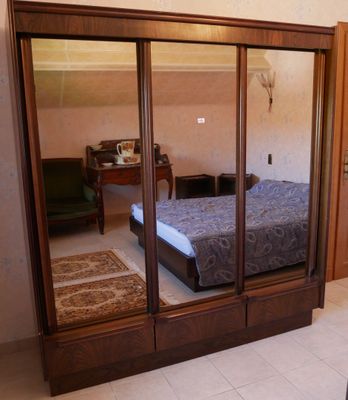 une chambre avec un lit et un miroir accroché au mur