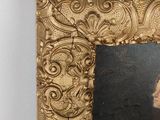 portrait of a woman in a gold frame with a black background