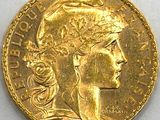 gros plan d'une pièce d'or sur une surface blanche
