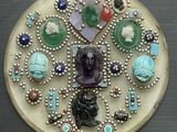 une photo d'une broche représentant une tête de femme entourée de bijoux