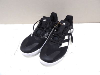 Des chaussures adidas posées sur une surface blanche, avec un fond blanc