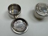 three metal containers sitting on top of a white table