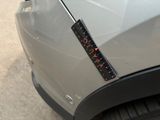 a sticker on the hood of a car with a ruler attached to it