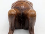 wooden figurine of a dog laying on its back on a white surface