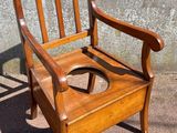 a wooden chair that has a toilet seat in it