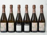 six bouteilles de vin sont alignées sur une table