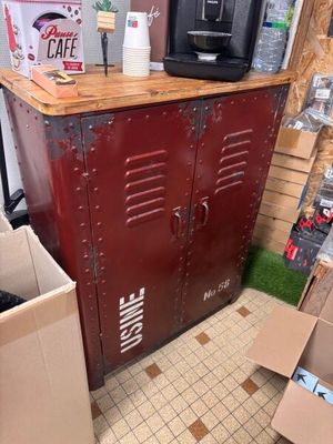 a red metal cabinet with a coffee maker on top of it