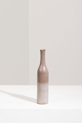 un vase marron posé sur une table blanche