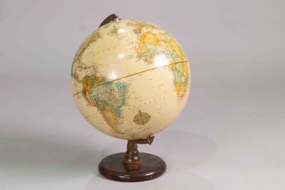 a small globe that is on a stand on a table