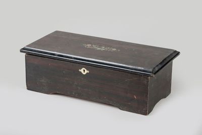 an old wooden box with a black lid and brass hardware