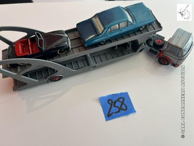 une petite voiture et un camion posés sur un train posé sur une table