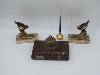 trois figurines d'oiseaux en laiton vieilli posées sur des socles en marbre, accompagnées d'une bougie