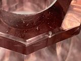 a glass ashtray with a metal bowl on top of it