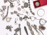 a lot of silver jewelry on a white surface