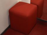 two red stools sitting next to a mirror in a room