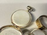 a silver pocket watch sitting on top of a white table